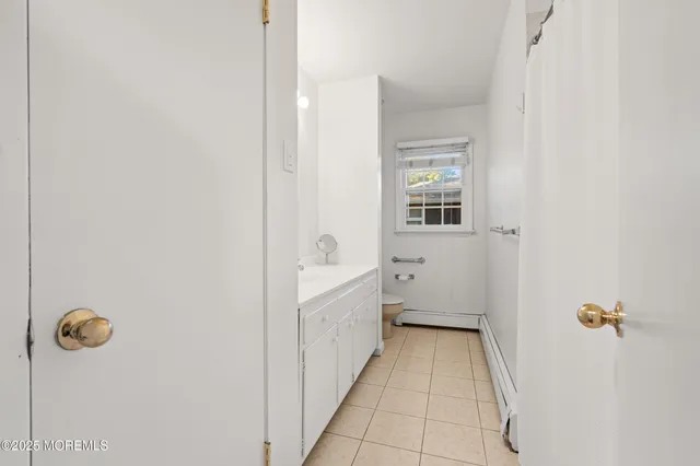 a bathroom with a granite countertop sink a window and tub