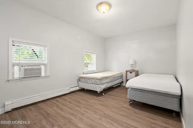 a bedroom with two beds and wooden floor