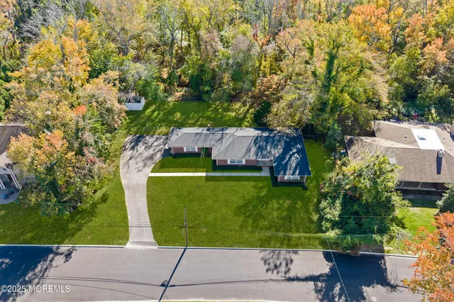 an aerial view of a house with a yard and trees