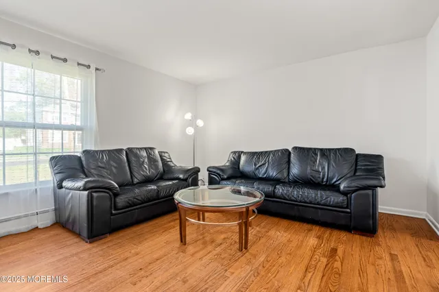 a living room with furniture a wooden floor and a window