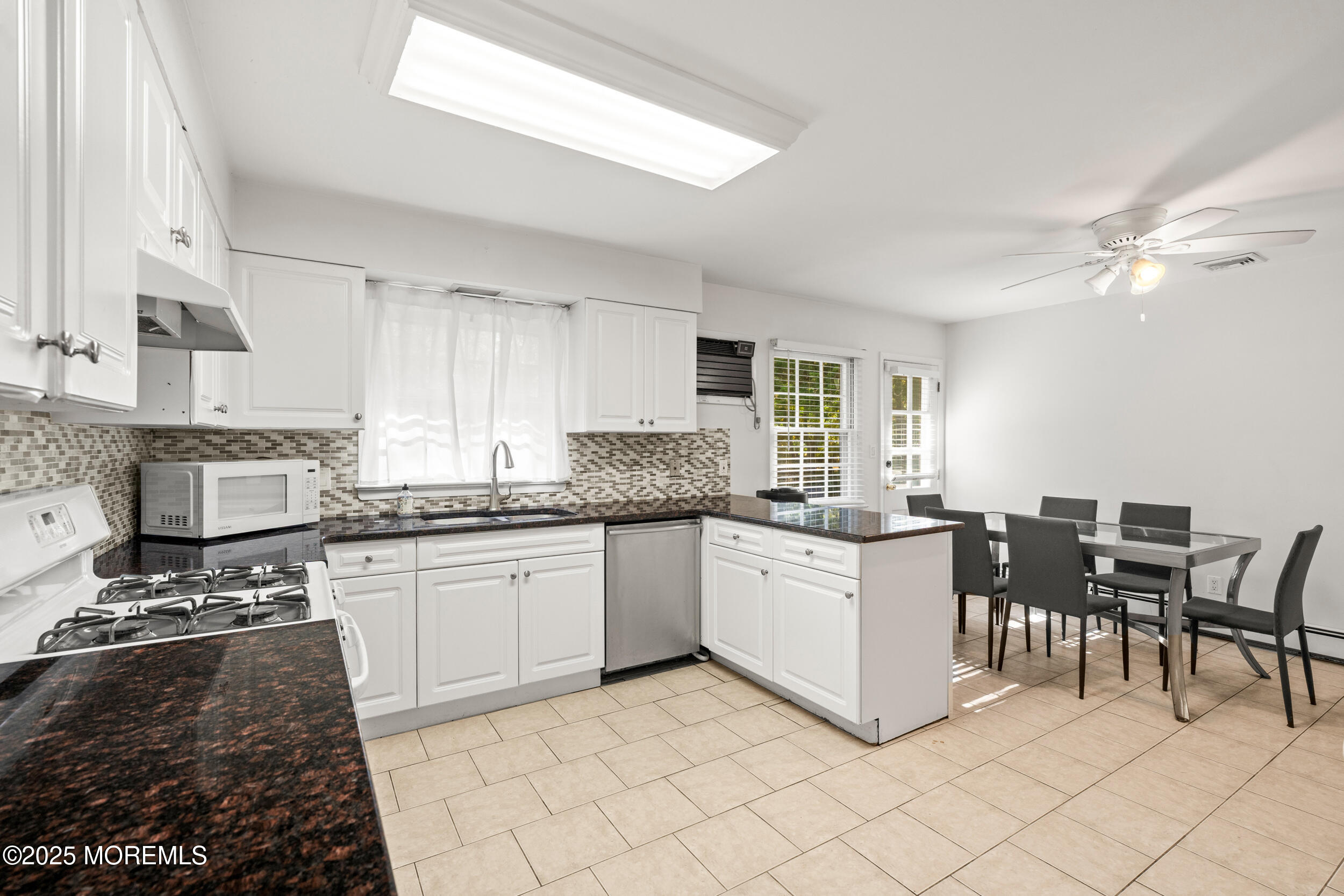 404 Brookside Avenue Oakhurst, NJ 07755 - Photo 9 of 43 a kitchen with stainless steel appliances granite countertop a stove top oven a sink a dining table and chairs