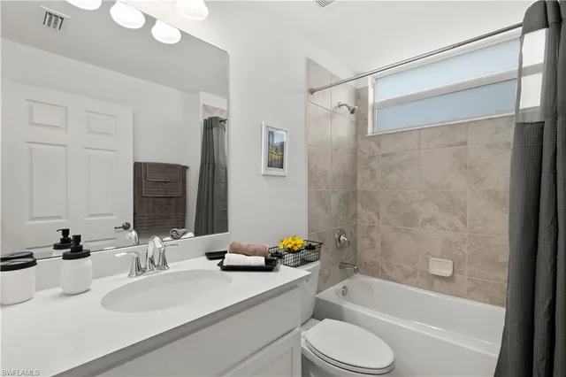 a bathroom with a sink vanity granite toilet tub and shower