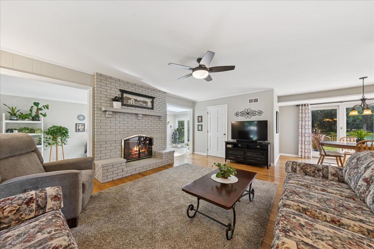 415 Hamilton Drive Wheaton, IL 60189 - Photo 12 of 27 a living room with furniture a flat screen tv and a fireplace
