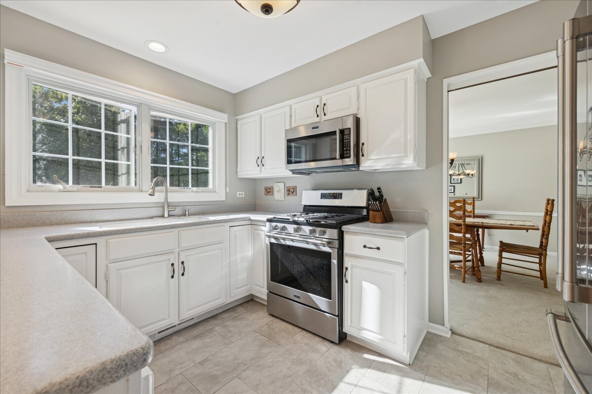 415 Hamilton Drive Wheaton, IL 60189 - Photo 4 of 27 a kitchen with stainless steel appliances granite countertop a stove a sink and a microwave
