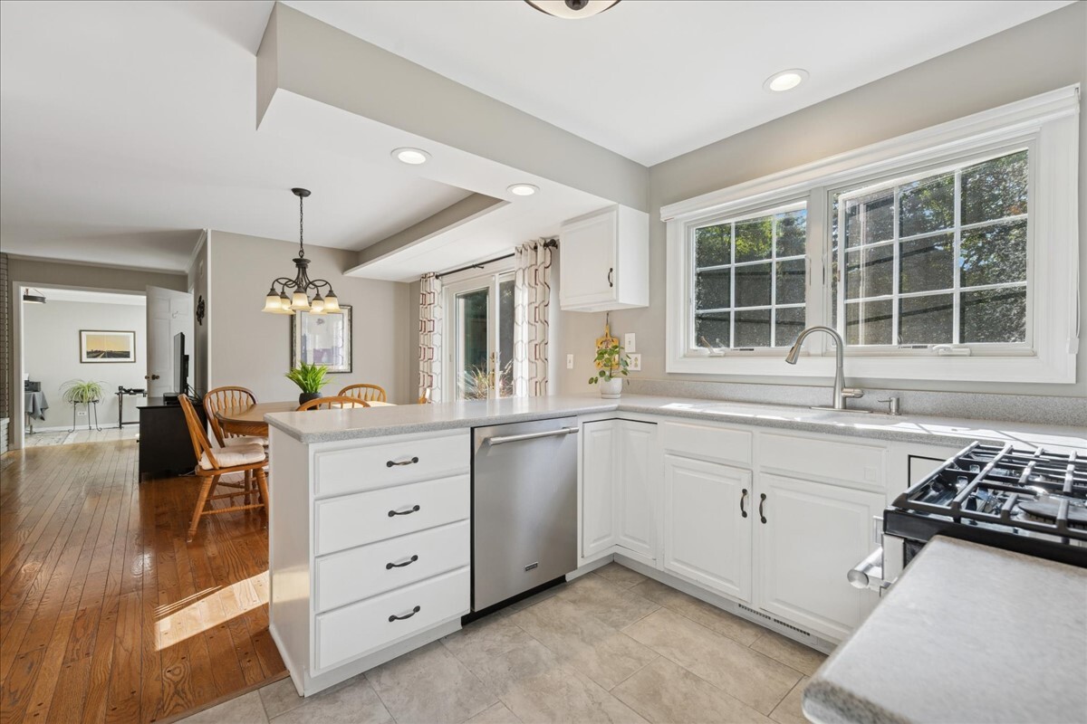 415 Hamilton Drive Wheaton, IL 60189 - Photo 5 of 27 a large white kitchen with granite countertop a stove a sink a window and white cabinets