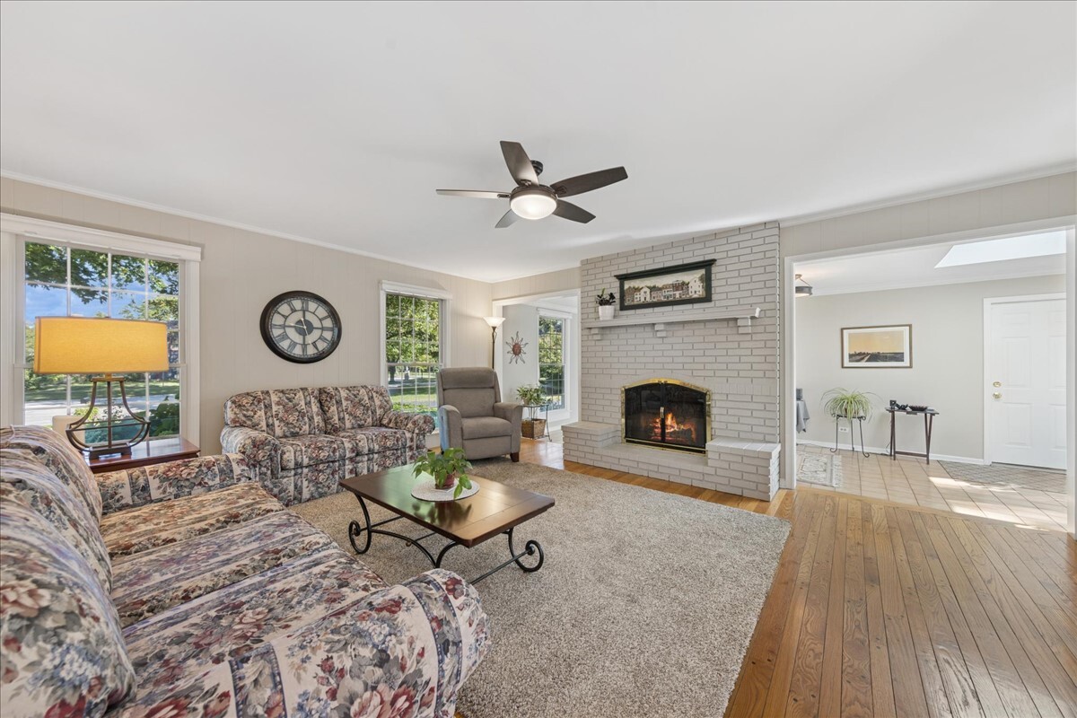 415 Hamilton Drive Wheaton, IL 60189 - Photo 9 of 27 a living room with furniture a clock and a fireplace