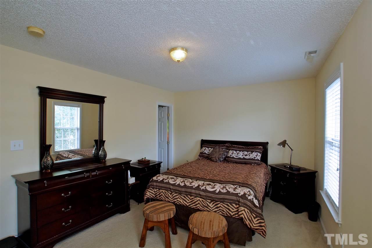 5106 Twisted Willow Way Raleigh, NC 27610 - Photo 13 of 22 a bedroom with a bed and a dresser