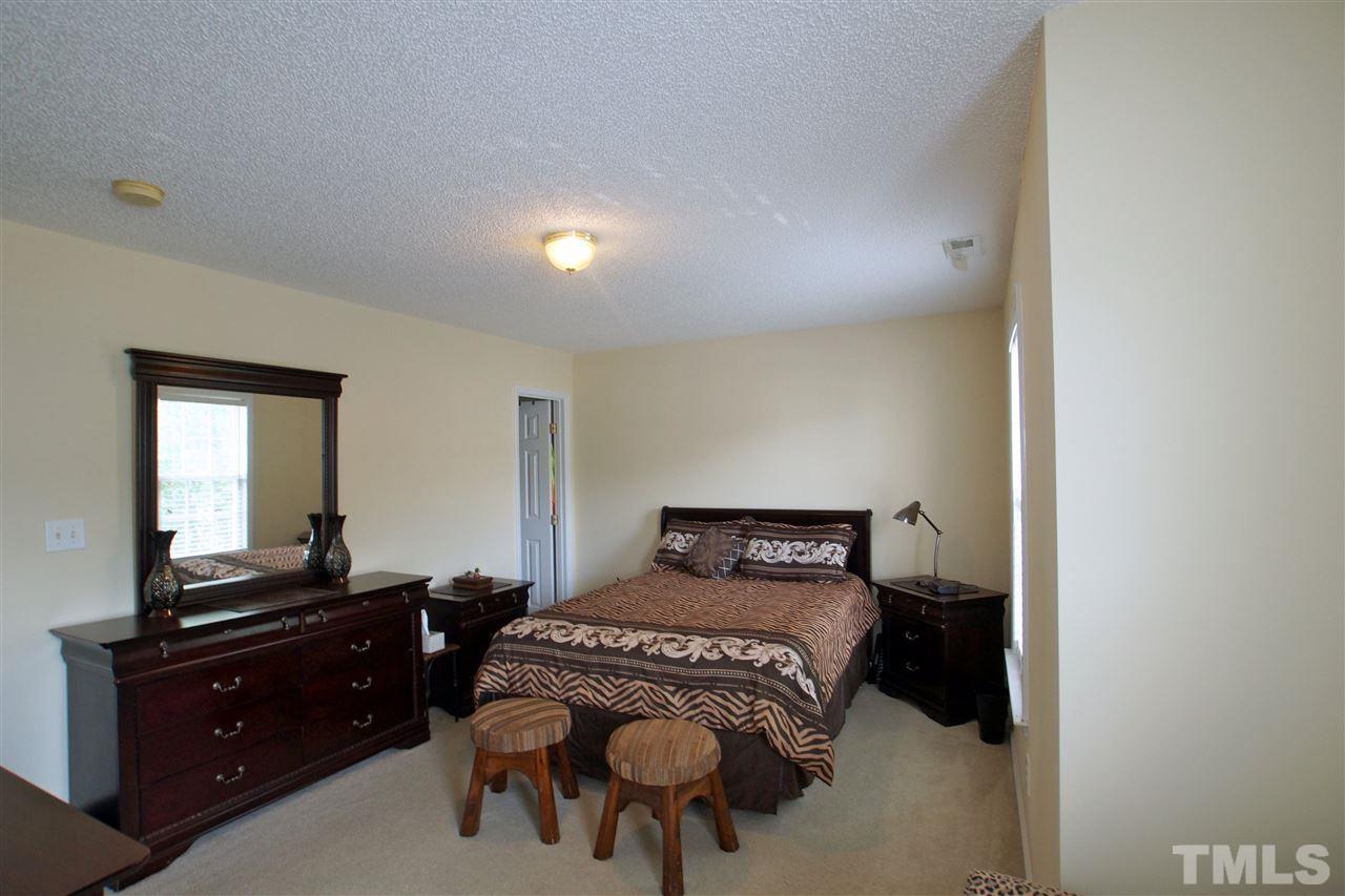 5106 Twisted Willow Way Raleigh, NC 27610 - Photo 14 of 22 a bedroom with a bed and a dresser