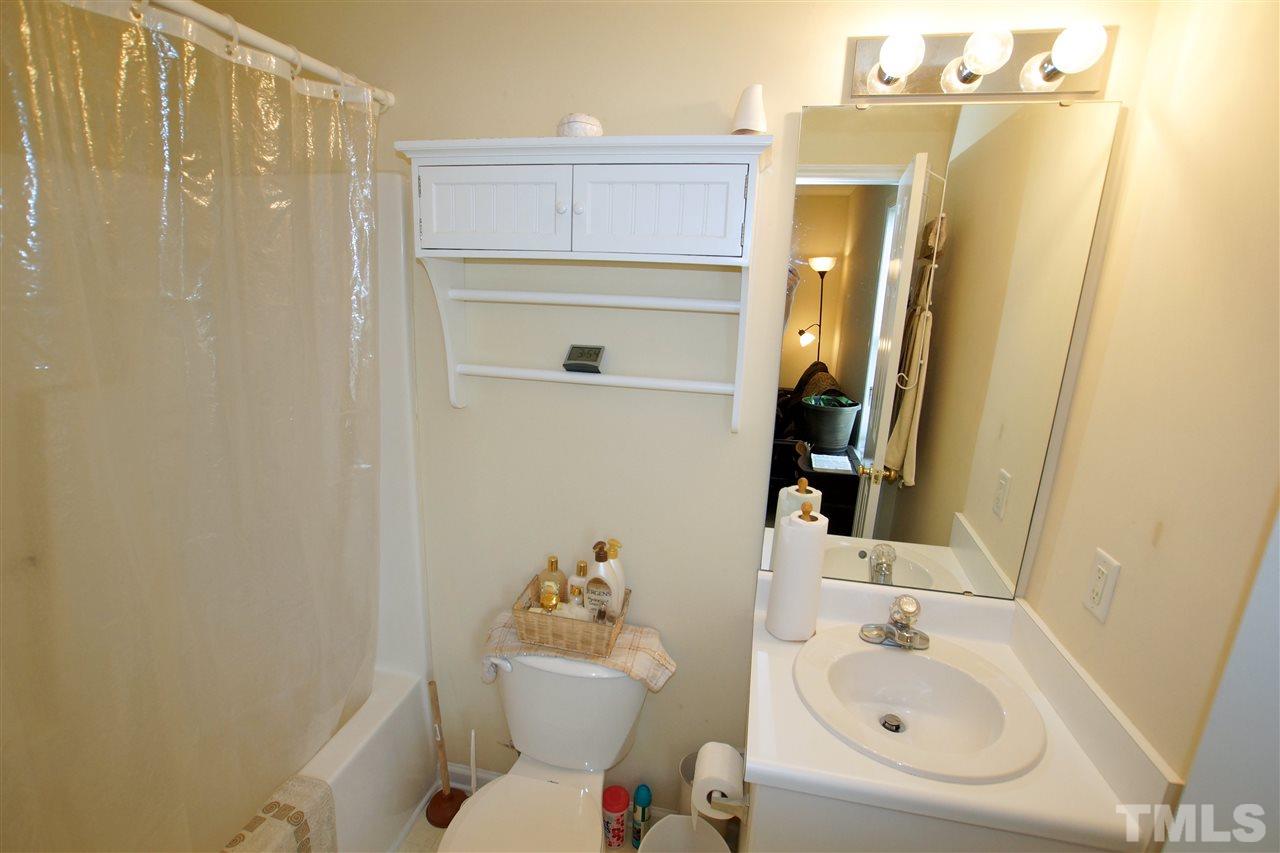 5106 Twisted Willow Way Raleigh, NC 27610 - Photo 19 of 22 a bathroom with a sink a toilet and shower curtain