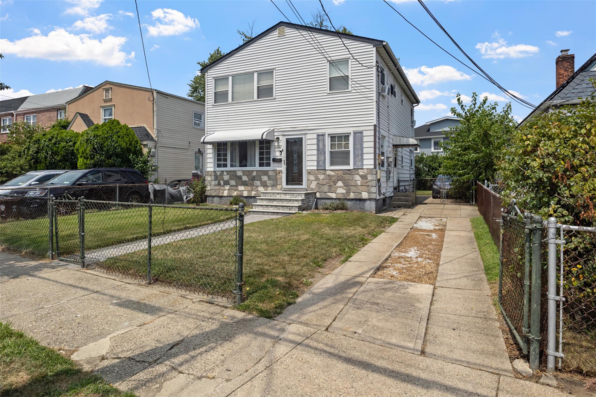 View of front of property featuring stone siding, a gate, and entry steps