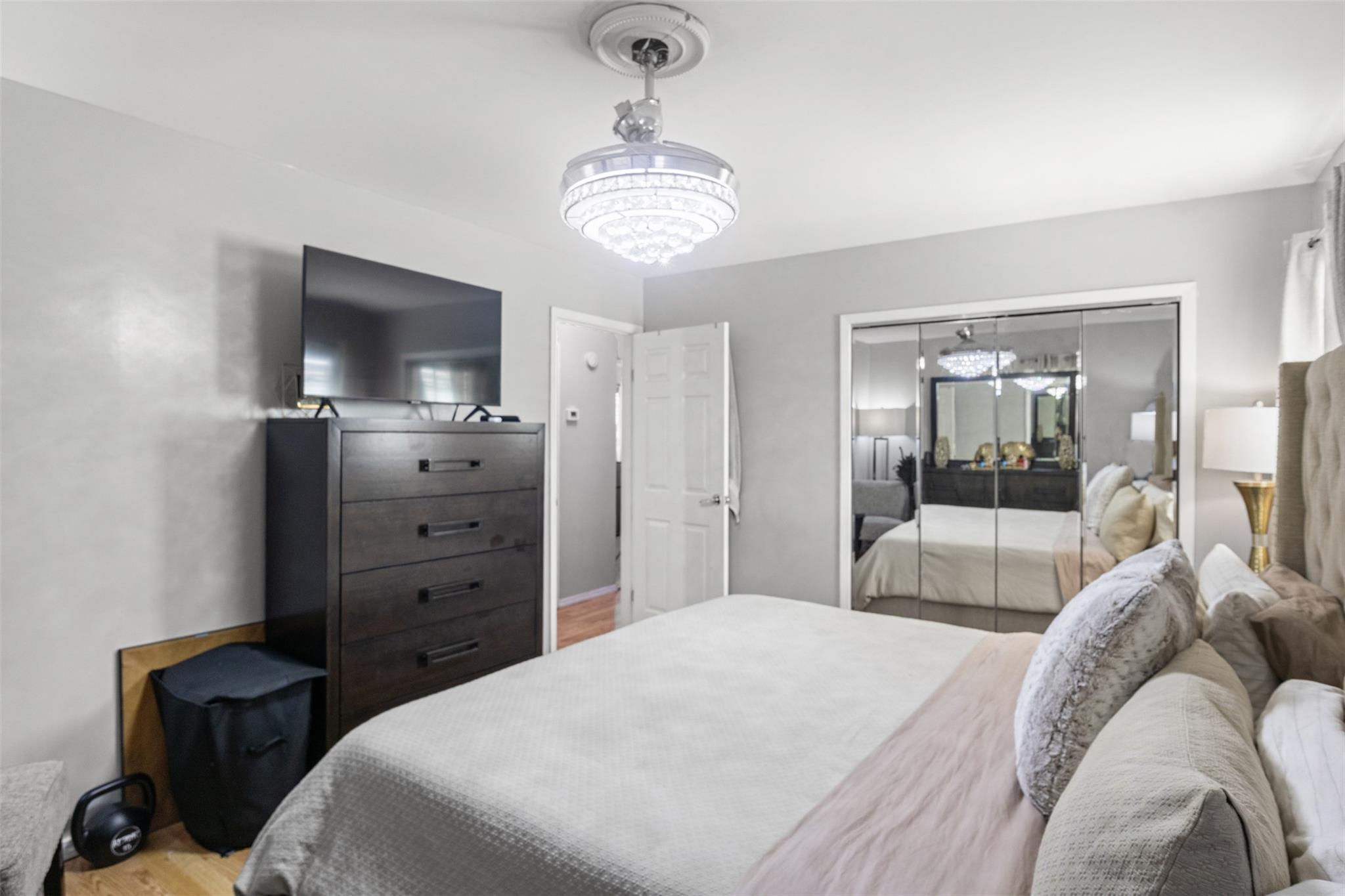 239-15 147th Road Queens, NY 11422 - Photo 15 of 28 Bedroom featuring a chandelier, wood finished floors, and a closet