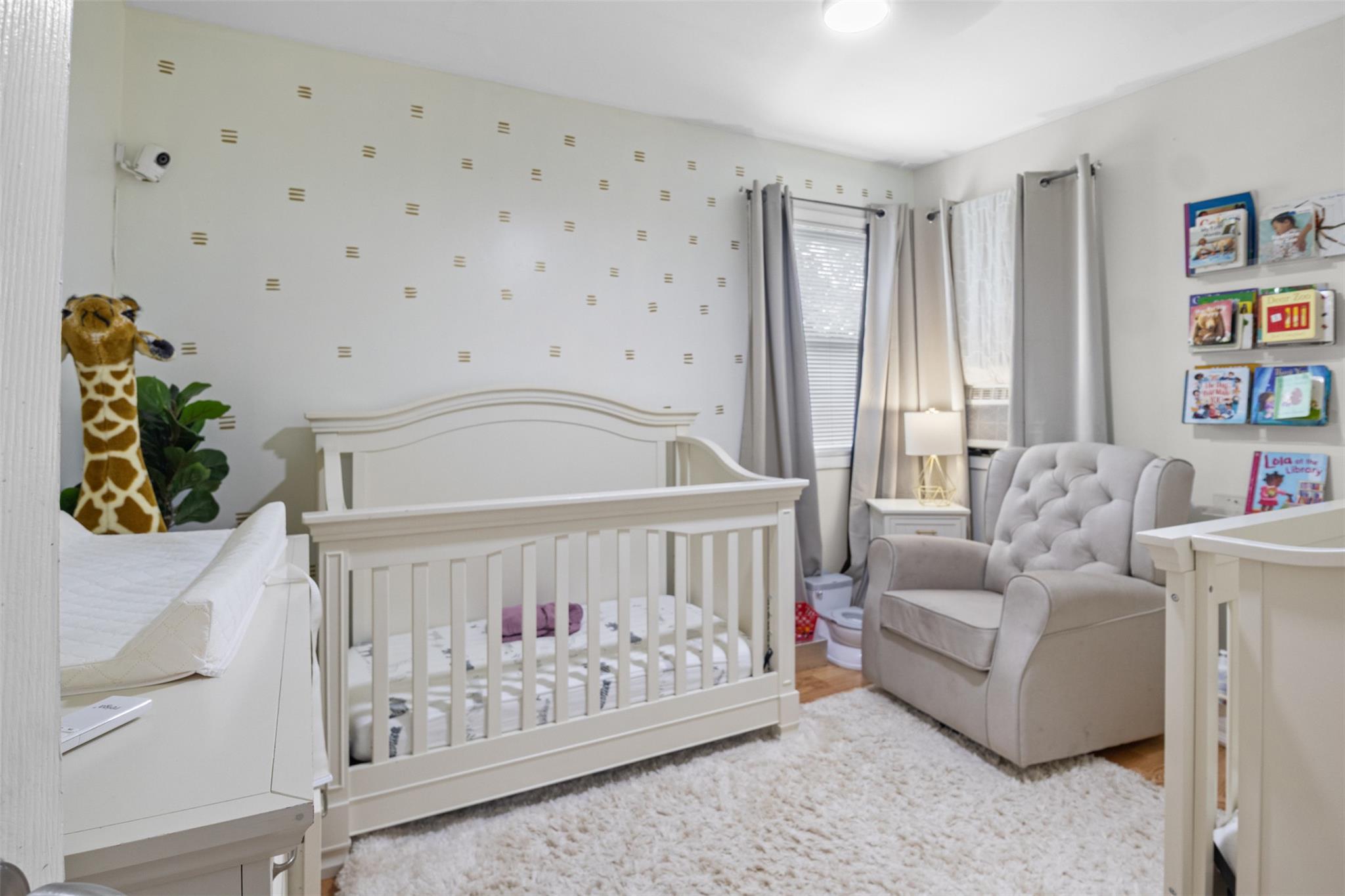 239-15 147th Road Queens, NY 11422 - Photo 17 of 28 Bedroom with wood finished floors and a crib