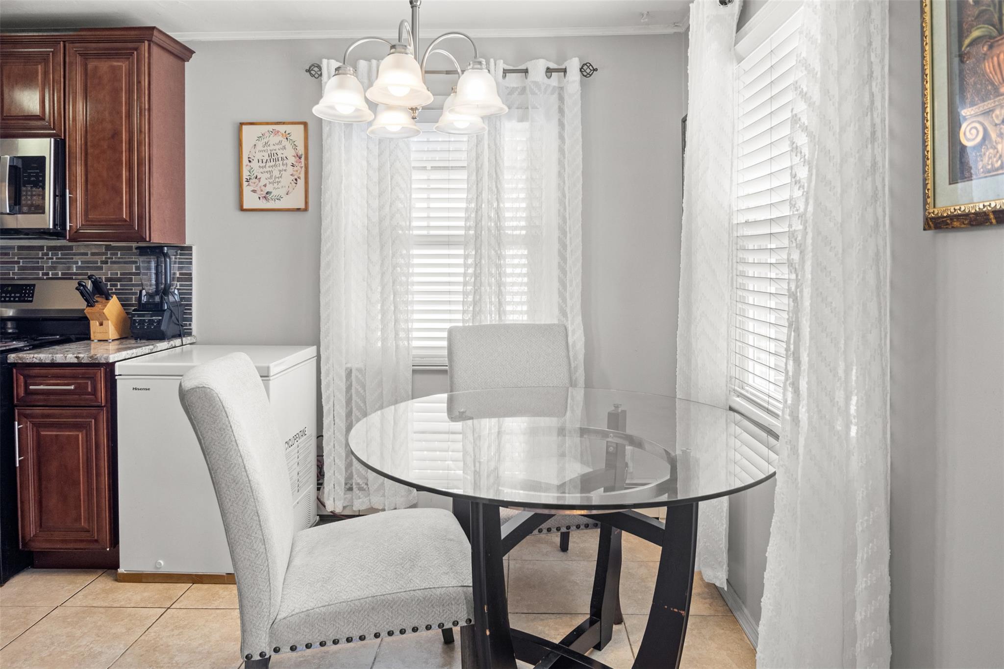 239-15 147th Road Queens, NY 11422 - Photo 3 of 28 Dining room featuring a chandelier, crown molding, and light tile patterned floors