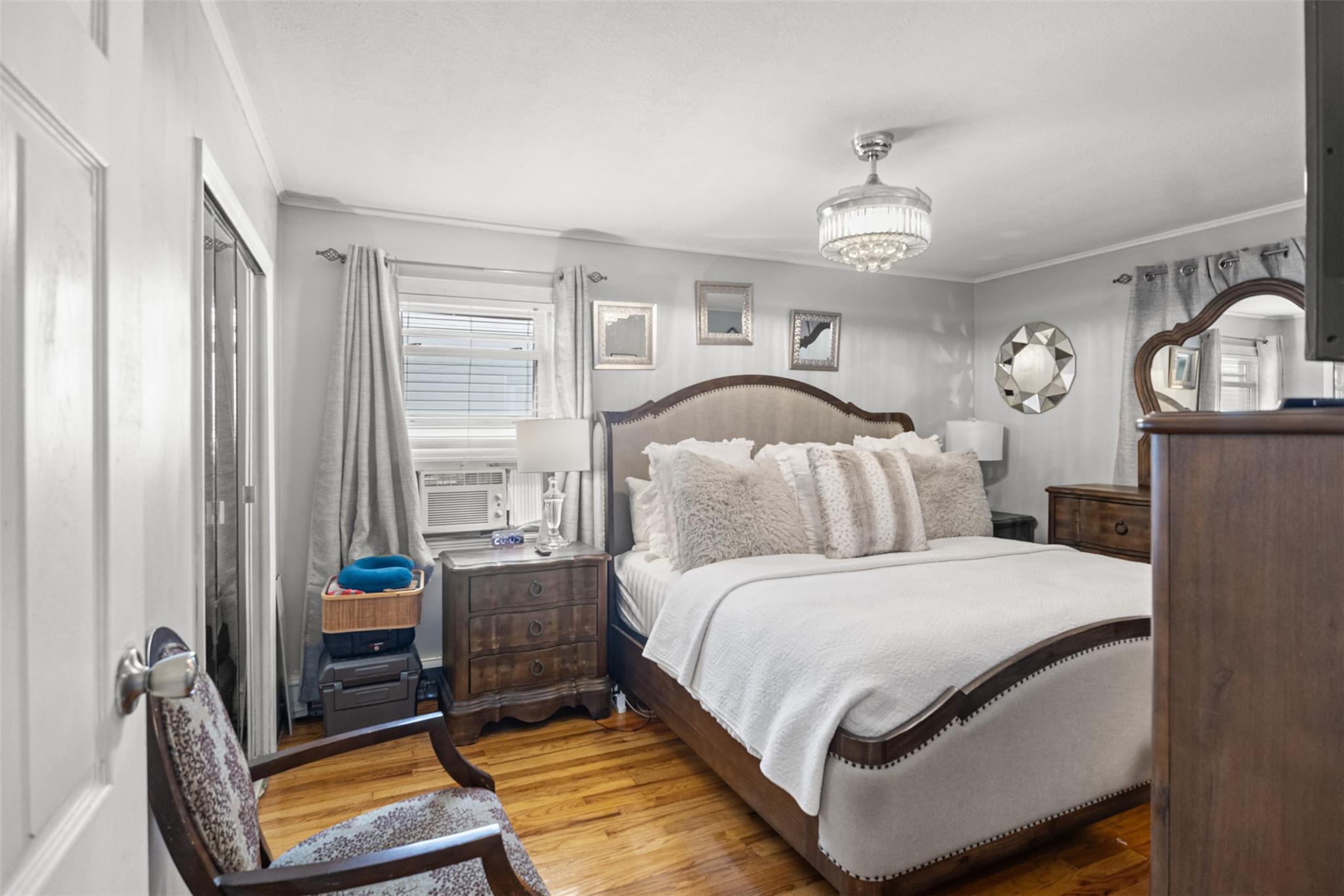 239-15 147th Road Queens, NY 11422 - Photo 8 of 28 Bedroom with wood finished floors, crown molding, and a chandelier