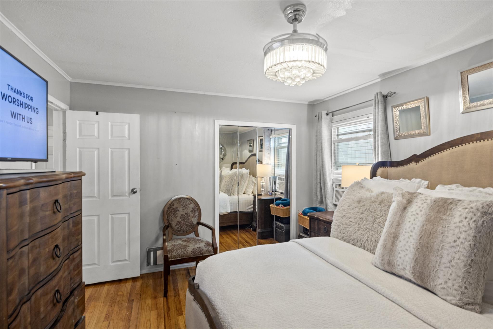 239-15 147th Road Queens, NY 11422 - Photo 9 of 28 Bedroom featuring crown molding, wood finished floors, and a chandelier