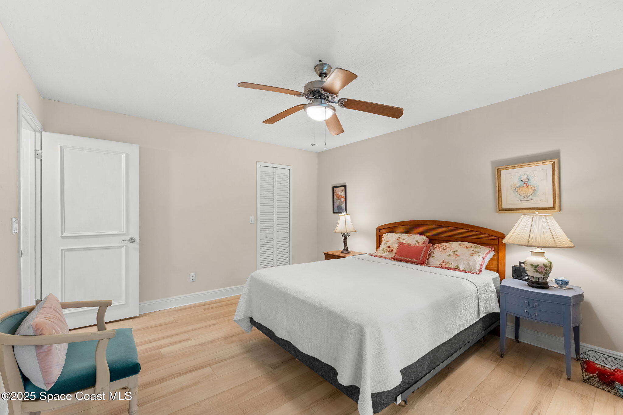7667 North Wickham Road, Unit 514 Melbourne, FL 32940 - Photo 11 of 37 a bedroom with a bed and a chandelier