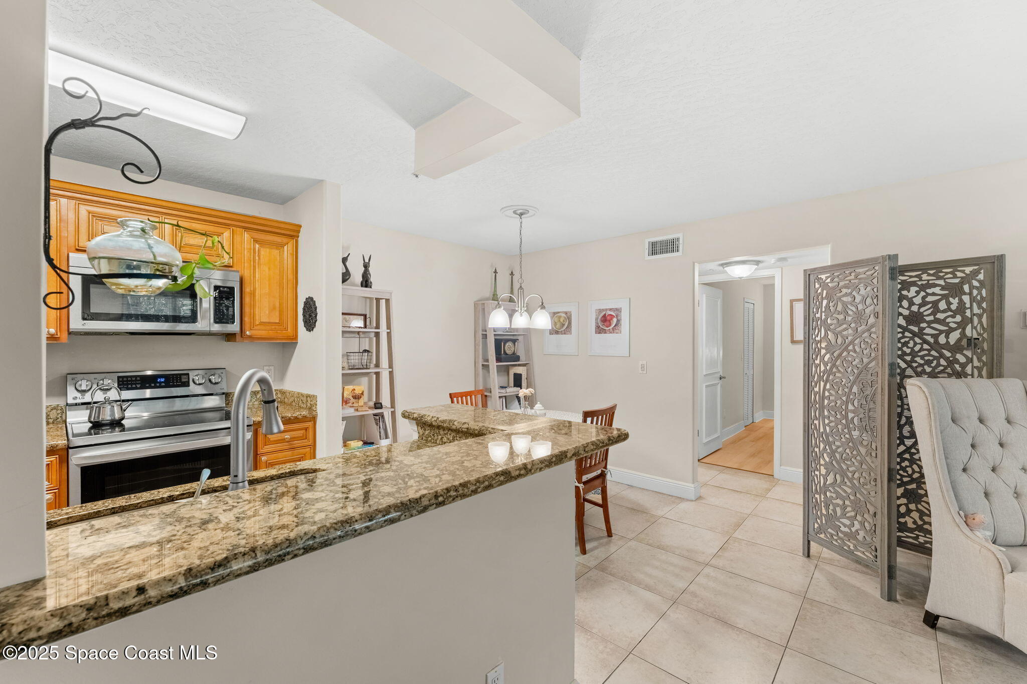 7667 North Wickham Road, Unit 514 Melbourne, FL 32940 - Photo 17 of 37 a kitchen with stainless steel appliances granite countertop a sink and a refrigerator