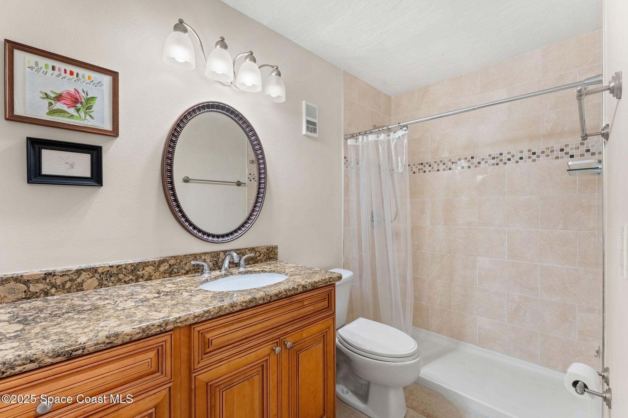 7667 North Wickham Road, Unit 514 Melbourne, FL 32940 - Photo 18 of 37 a bathroom with a granite countertop sink mirror vanity and toilet