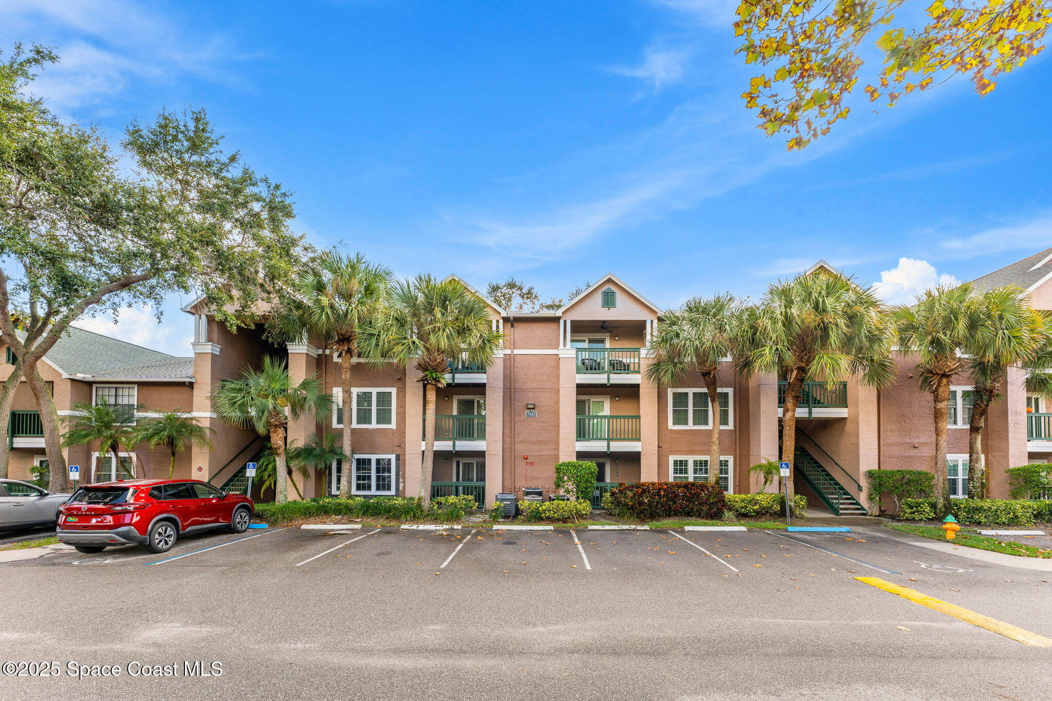 7667 North Wickham Road, Unit 514 Melbourne, FL 32940 - Photo 7 of 37 a front view of a building with lot of cars parked on road