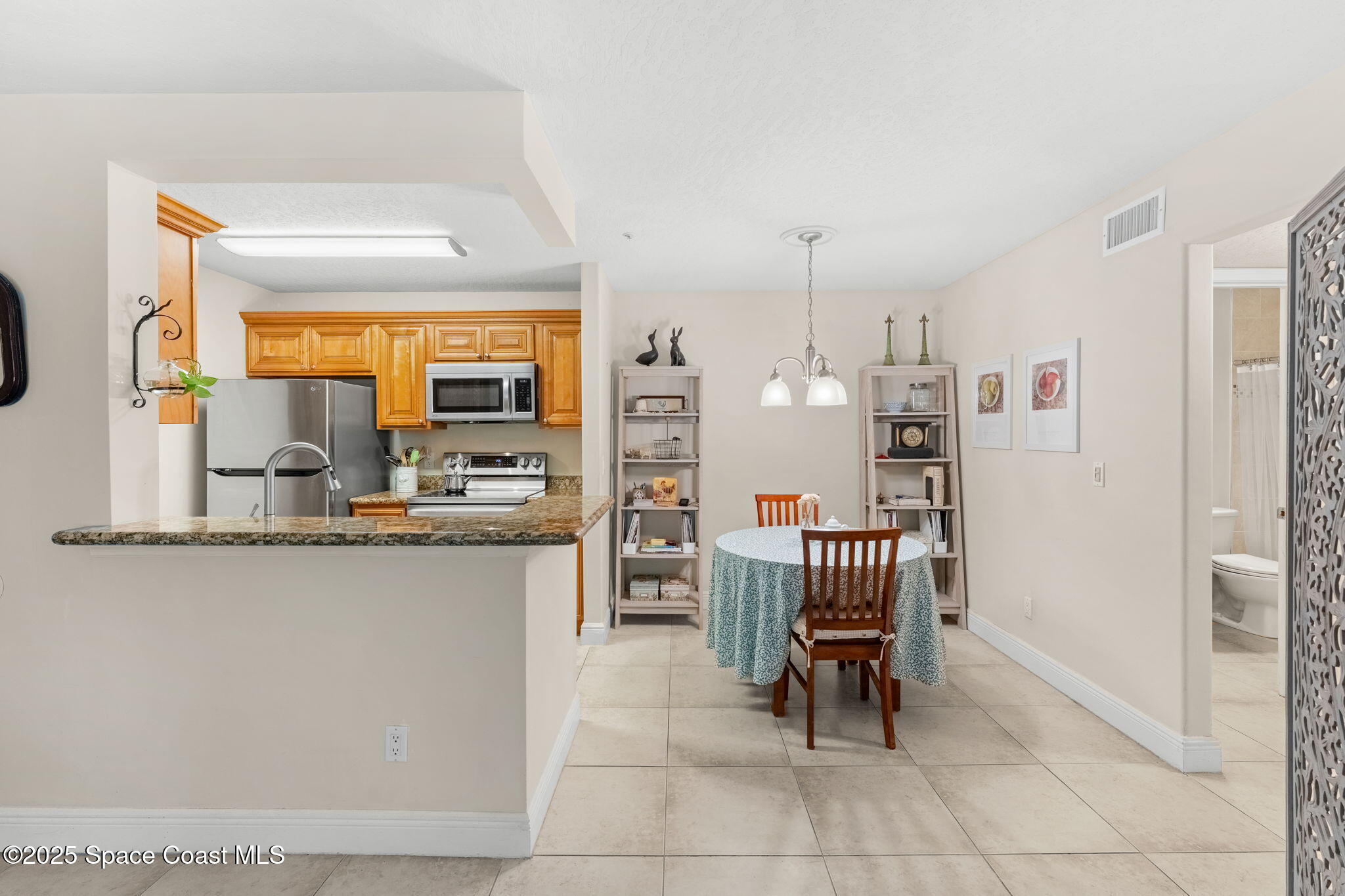 7667 North Wickham Road, Unit 514 Melbourne, FL 32940 - Photo 10 of 37 a kitchen with granite countertop sink a table and chairs