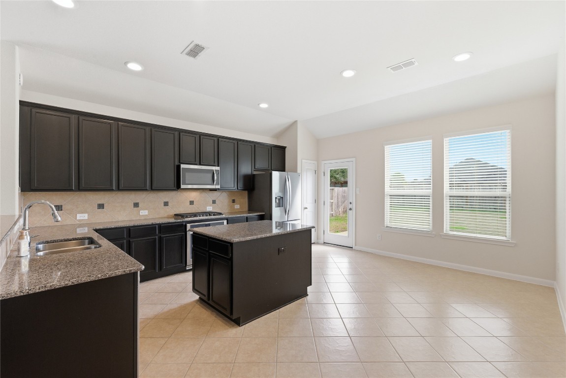 3418 Delta Drive Rosharon, TX 77583 - Photo 11 of 38 a kitchen with stainless steel appliances granite countertop a stove top oven a sink dishwasher and a refrigerator with wooden cabinets