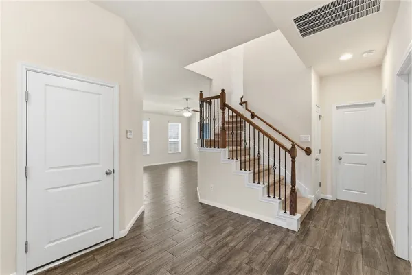 a view of a hallway with wooden floor and staircase