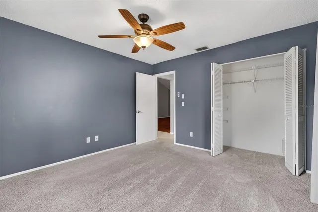 a view of an empty room with a ceiling fan
