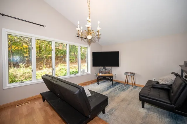 a living room with furniture a flat screen tv and a large window