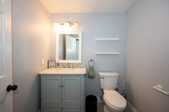 a bathroom with a toilet a sink and mirror
