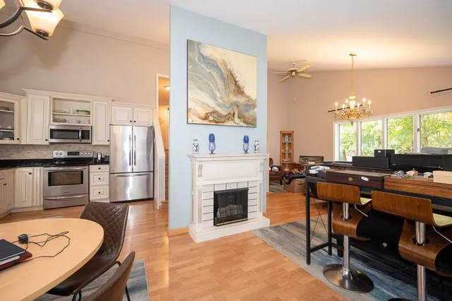 a kitchen with stainless steel appliances a stove a sink a dining table and chairs