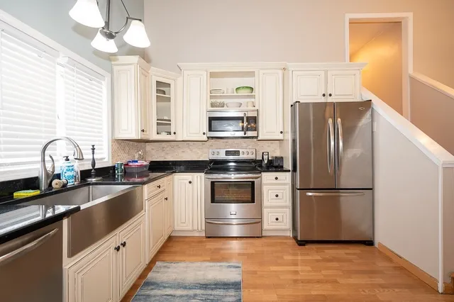 a kitchen with granite countertop a refrigerator oven a sink and dishwasher