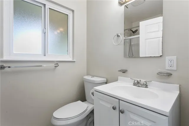 a bathroom with a sink a toilet and mirror