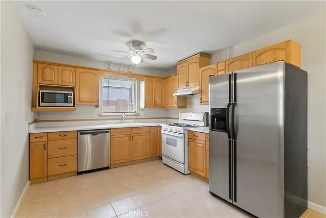 a kitchen with stainless steel appliances granite countertop a refrigerator sink and stove