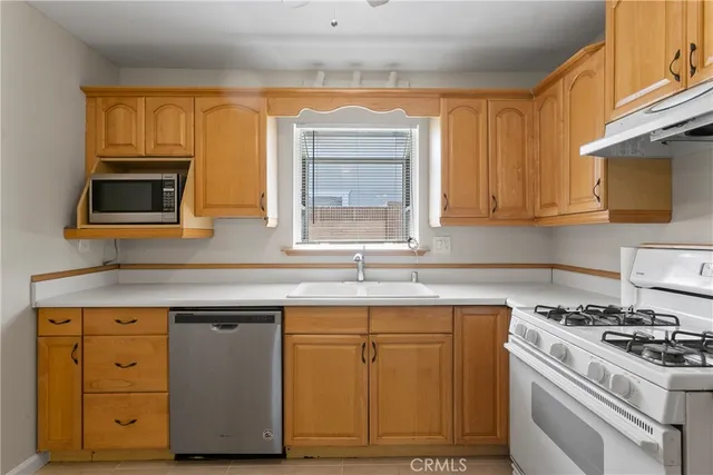 a kitchen with cabinets appliances and a window