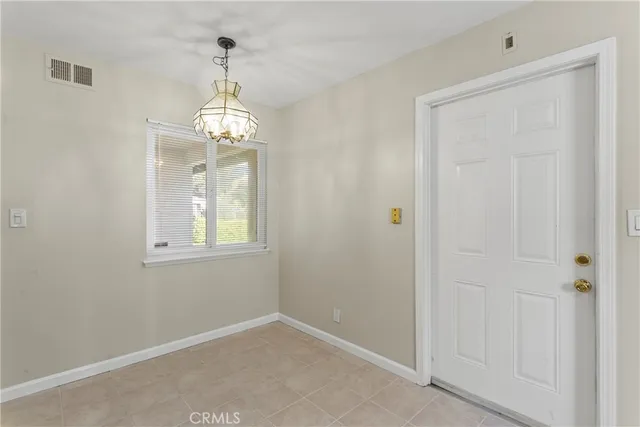 en empty room with windows and chandelier