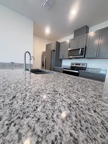 a kitchen with stainless steel appliances a sink a stove a refrigerator cabinets