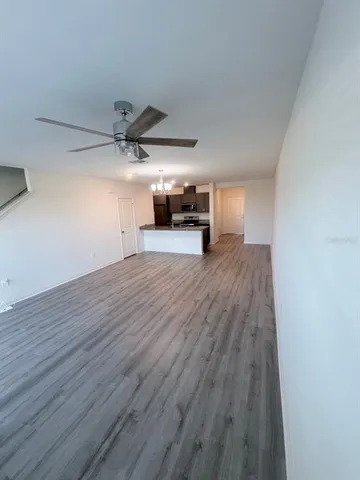 a view of a livingroom with wooden floor and a ceiling fan