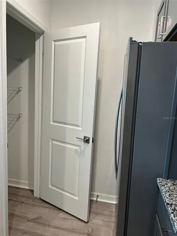 an empty refrigerator freezer and a wooden floor