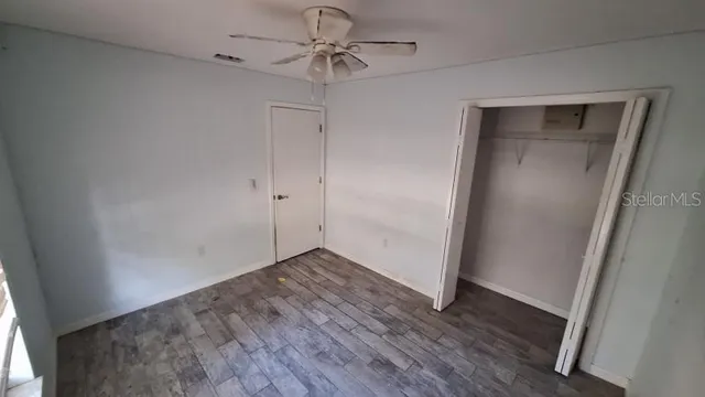 a view of a room with wooden floor and fan