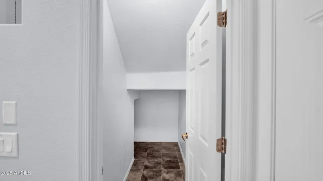 a view of a hallway with white walls and stairs