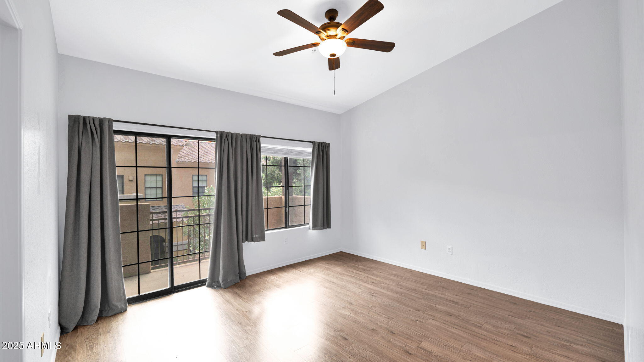 1702 East Bell Road, Unit 113 Phoenix, AZ 85022 - Photo 16 of 32 a view of a big room with wooden floor and a ceiling fan