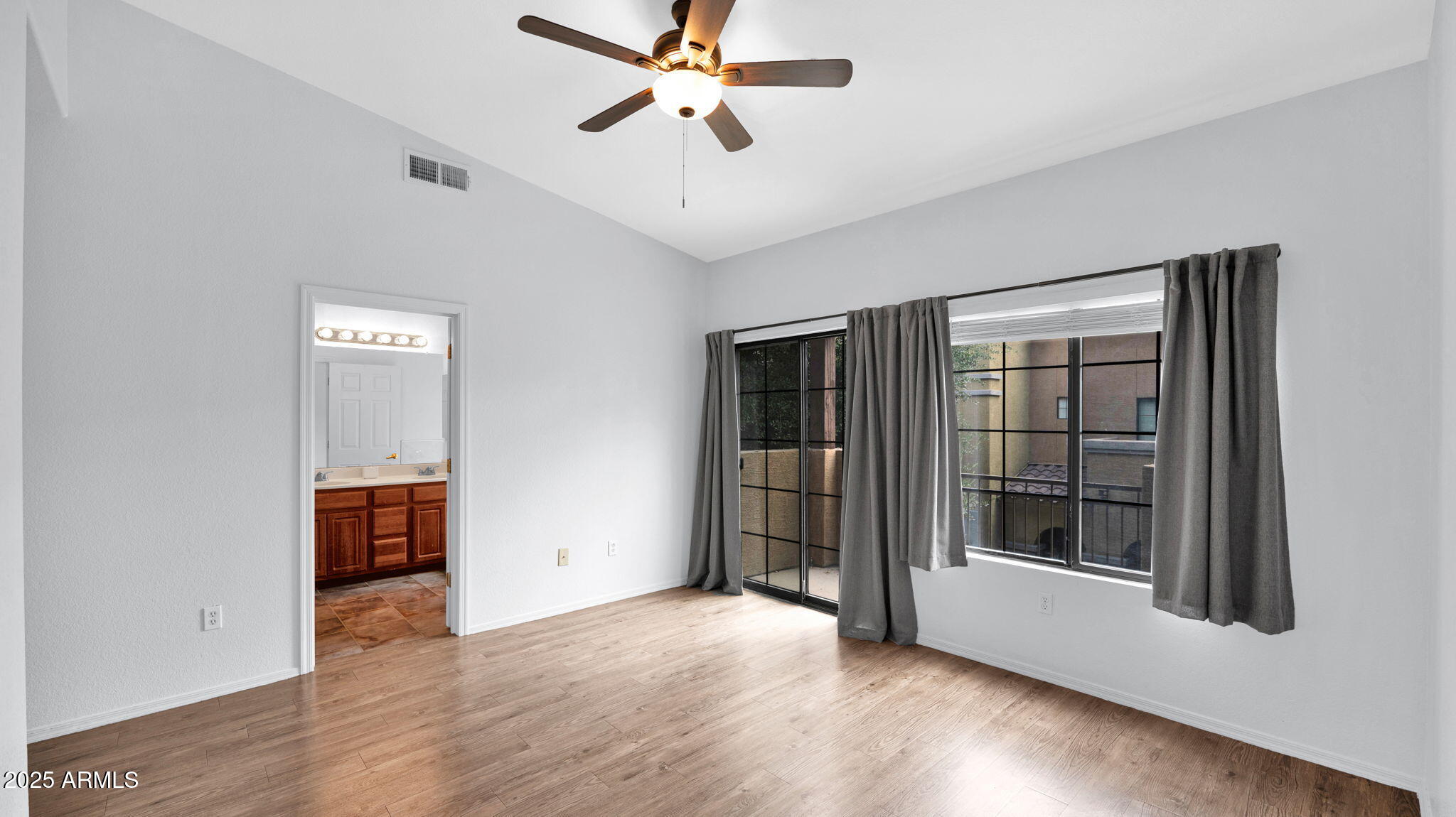 1702 East Bell Road, Unit 113 Phoenix, AZ 85022 - Photo 17 of 32 a view of an empty room with wooden floor and a window