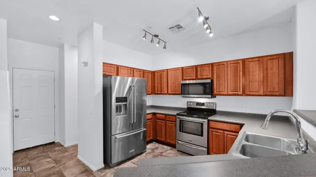 a kitchen with stainless steel appliances granite countertop a refrigerator stove and microwave