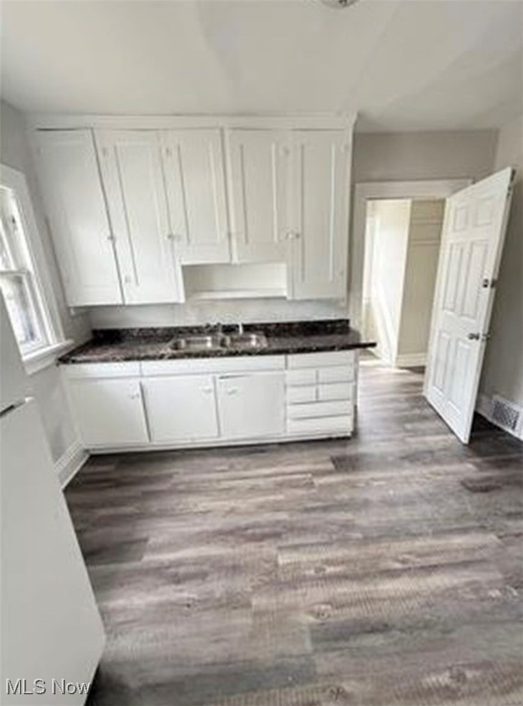 1754 Algonac Road Cleveland, OH 44112 - Photo 4 of 9 Kitchen featuring white cabinetry, dark countertops, and dark wood-style floors