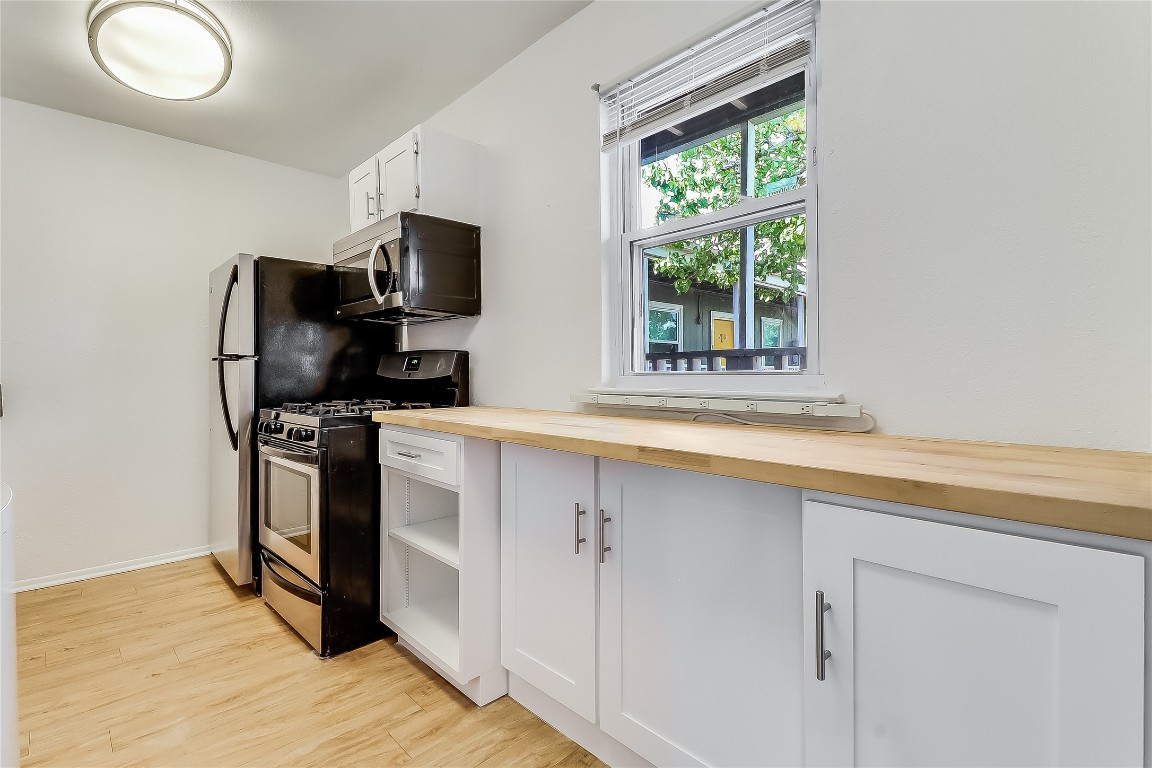 2401 Manor Road, Unit 210 Austin, TX 78722 - Photo 11 of 20 a kitchen with a sink wooden floor and a window