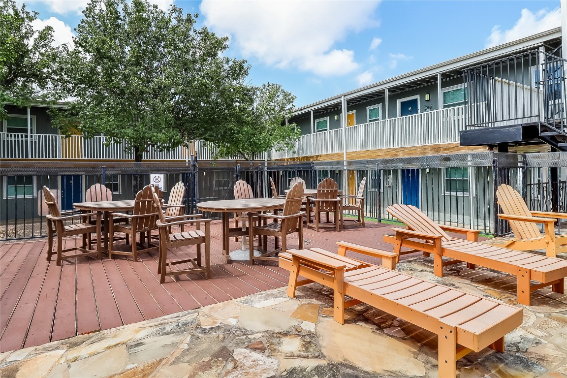 2401 Manor Road, Unit 210 Austin, TX 78722 - Photo 19 of 20 a view of a patio with a dining table and chairs with wooden floor and fence