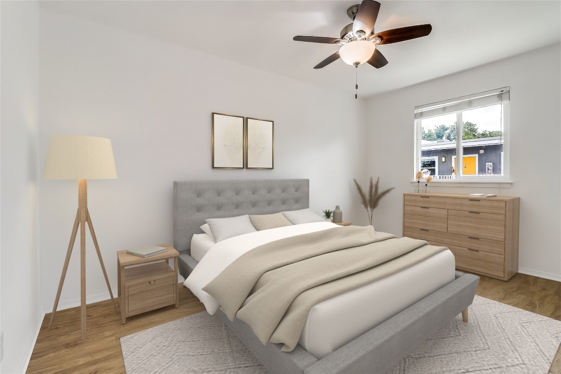 2401 Manor Road, Unit 210 Austin, TX 78722 - Photo 2 of 20 a bedroom with a bed and a chandelier