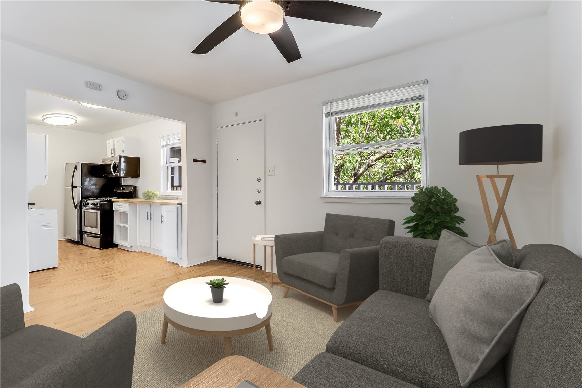 2401 Manor Road, Unit 210 Austin, TX 78722 - Photo 4 of 20 a living room with furniture and a wooden floor