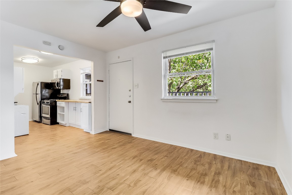 2401 Manor Road, Unit 210 Austin, TX 78722 - Photo 5 of 20 a view of a kitchen with a sink a refrigerator a kitchen and a window