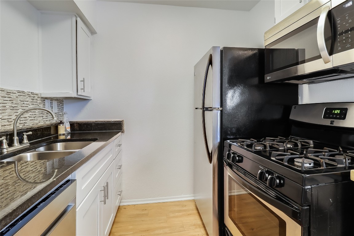 2401 Manor Road, Unit 210 Austin, TX 78722 - Photo 8 of 20 a kitchen with stainless steel appliances granite countertop a sink stove and refrigerator